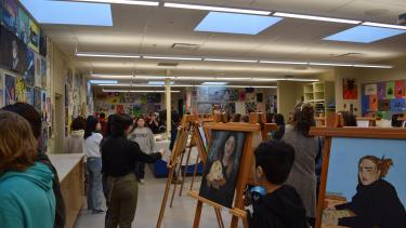 Art displays set up for Art show. Students walking around looking at art pieces