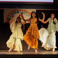 Group of students on stage performing a bhangra dance