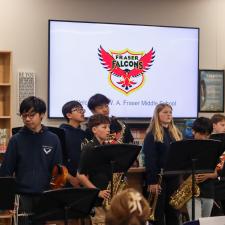 Students holding instruments prepare to preform in front of the audience